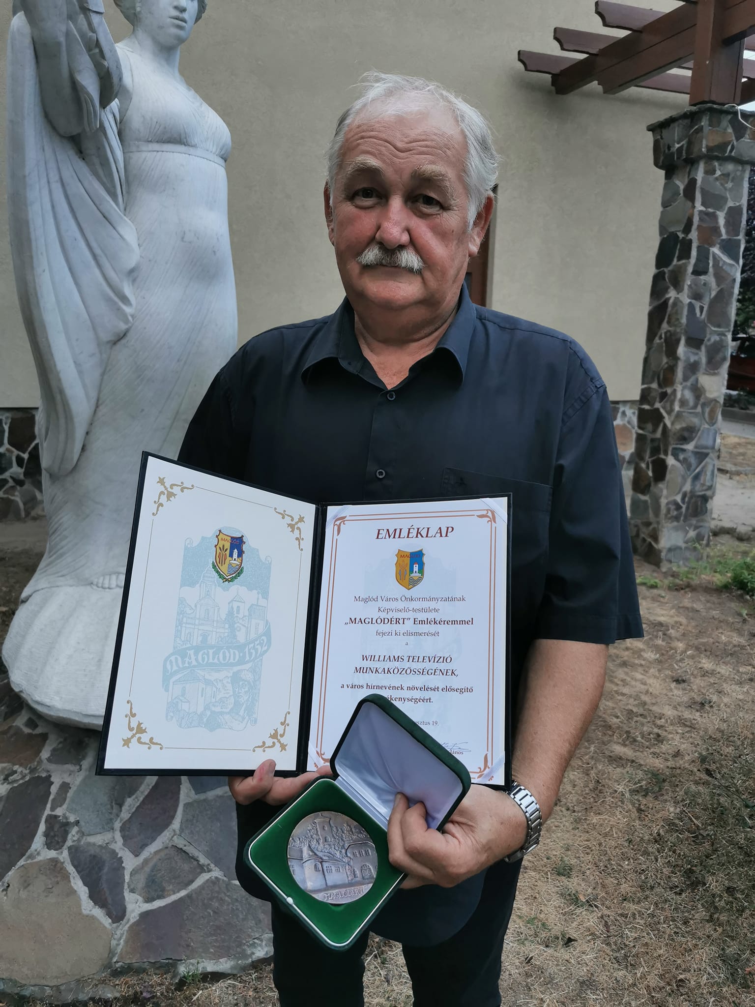 Kortye Vilmos, a Williams Televízió tulajdonosa, kezében Maglódért emlékéremmel